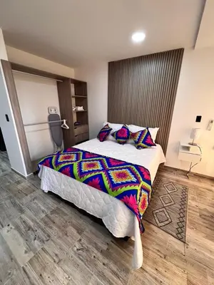 a bedroom with a large bed with a colorful comforter at Meraki Urban Lofts in Quibdó