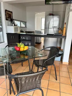 a glass table with a bowl of fruit on it in a kitchen at Cabaña San Jerónimo in San Jerónimo