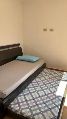 a small bedroom with a bed with a blue pillow at Cabaña San Jerónimo in San Jerónimo