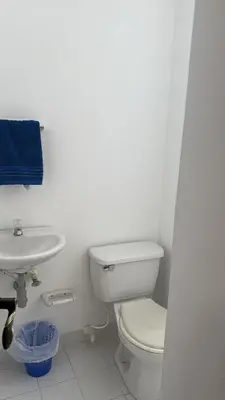a white bathroom with a toilet and a sink at Cabaña San Jerónimo in San Jerónimo