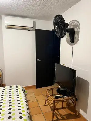 a bedroom with a tv and a black door at Cabaña ciudadela premium San Jerónimo in San Jerónimo