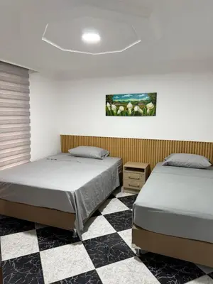 a bedroom with two beds and a checkered floor at Hermoso,amplio y central apartamento en Medellin in Medellín