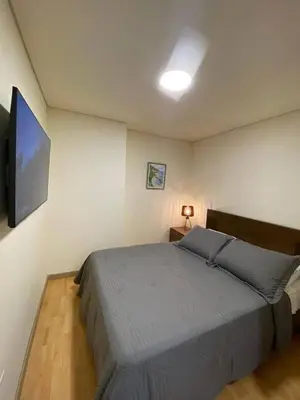 a bedroom with a bed and a flat screen tv at San Telmo - Guatape with Hot Tube in Guatapé