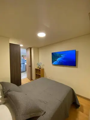 a bedroom with a bed with a television on the wall at San Telmo - Guatape with Hot Tube in Guatapé