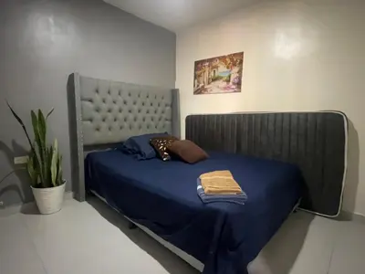 a bedroom with a bed with a blue comforter at Glen de 3 alcobas los molinos in Medellín