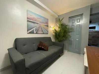 a living room with a couch and a painting on the wall at Glen de 3 alcobas los molinos in Medellín