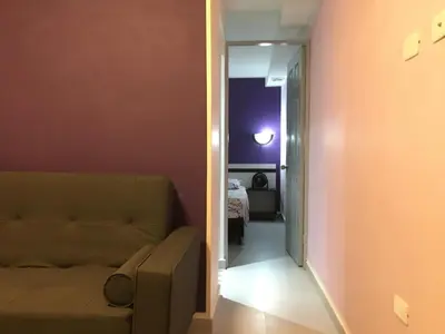 a living room with a couch and a hallway at Glen de 3 alcobas los molinos in Medellín