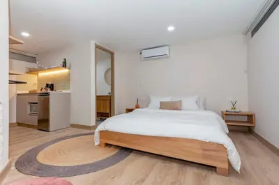 a bedroom with a large bed and a kitchen at Cozy Apt 4 -Laureles -AC- Smart Lock in Medellín