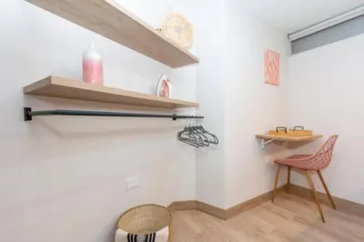 a room with white walls and wooden shelves and a chair at Cozy Apt 4 -Laureles -AC- Smart Lock in Medellín
