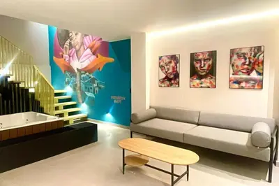 a living room with a couch and some pictures on the wall at 7BR Poblado House close to Lleras Park Jacuzzi AC in Medellín