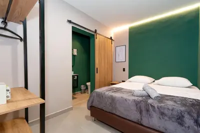 a bedroom with a large bed with a green headboard at 7BR Poblado House close to Lleras Park Jacuzzi AC in Medellín