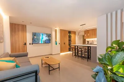 a living room and kitchen with a couch and a table at 7BR Poblado House close to Lleras Park Jacuzzi AC in Medellín