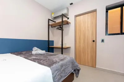a bedroom with a bed and a wooden door at 7BR Poblado House close to Lleras Park Jacuzzi AC in Medellín