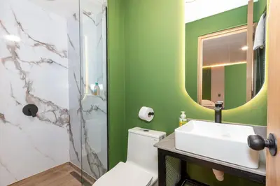 a bathroom with a white toilet and a sink at 7BR Poblado House close to Lleras Park Jacuzzi AC in Medellín