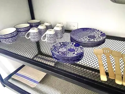 a shelf with blue and white plates and utensils at R301 Apartment close to Lleras park and Provenza in Medellín