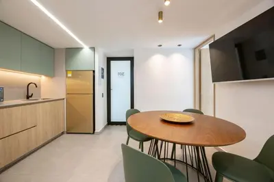 a kitchen and dining room with a wooden table and green chairs at L301 4BR Lleras Park Apt Rooftop Jacuzzi AC in Medellín