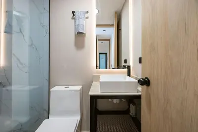 a bathroom with a white toilet and a sink at L301 4BR Lleras Park Apt Rooftop Jacuzzi AC in Medellín