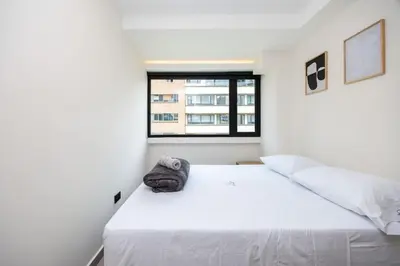 a bedroom with a white bed with a window at L301 4BR Lleras Park Apt Rooftop Jacuzzi AC in Medellín