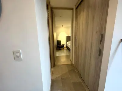 a hallway leading to a room with a bed and a mirror at SF501 Poblado Manila KBed Parking 247 security in Medellín