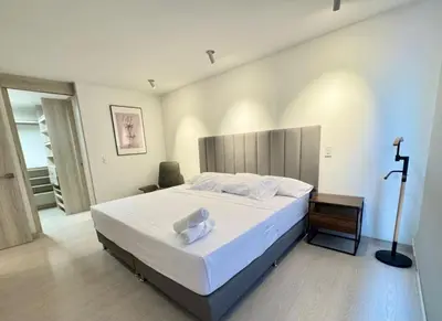a bedroom with a large bed and a cross on the wall at SF501 Poblado Manila KBed Parking 247 security in Medellín
