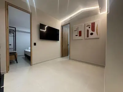 a room with a hallway with a television and a mirror at 5BR Poblado House to close LlerasPark Jacuzzi AC in Medellín