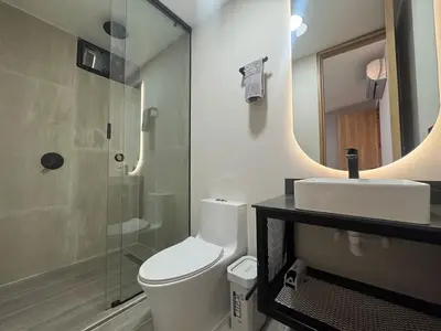 a bathroom with a toilet and a sink and a mirror at 5BR Poblado House to close LlerasPark Jacuzzi AC in Medellín