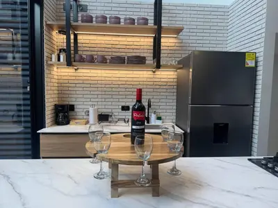 a bottle of wine sitting on a table with wine glasses at 5BR Poblado House to close LlerasPark Jacuzzi AC in Medellín