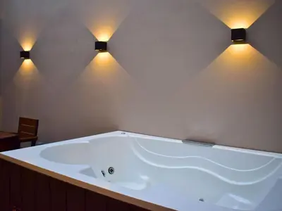 a large bath tub with two lights on the wall at 5BR Poblado House to close LlerasPark Jacuzzi AC in Medellín