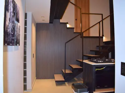 a staircase in a house with a black railing at 5BR Poblado House to close LlerasPark Jacuzzi AC in Medellín