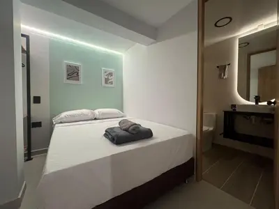 a bedroom with a bed and a bathroom with a sink at 5BR Poblado House to close LlerasPark Jacuzzi AC in Medellín