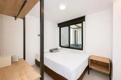 a small bedroom with a bed and a window at M501 Poblado Apt close to lleras park jacuzzi AC in Medellín