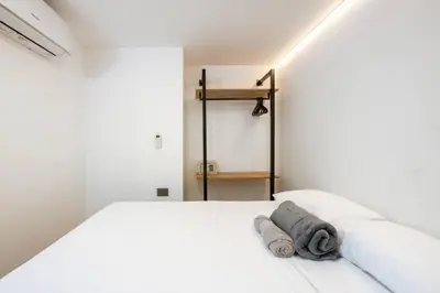 a bedroom with a white bed with a towel on it at M501 Poblado Apt close to lleras park jacuzzi AC in Medellín