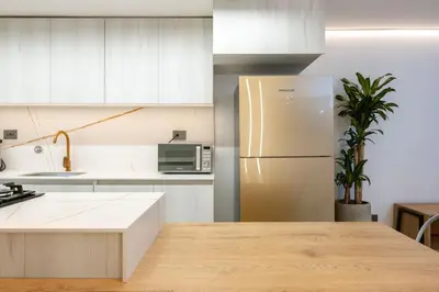 a kitchen with white cabinets and a refrigerator at M501 Poblado Apt close to lleras park jacuzzi AC in Medellín