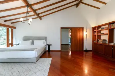 a bedroom with a large bed and wooden floors at CH51 Colonial Charm Villa at El Poblado Jacuzzi in Medellín
