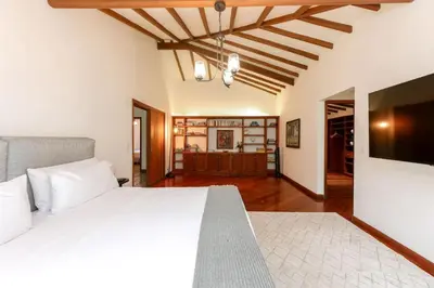 a bedroom with a white bed and a television at CH51 Colonial Charm Villa at El Poblado Jacuzzi in Medellín