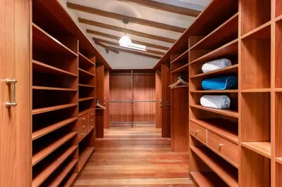 a walk in closet with wooden cabinets and shelves at CH51 Colonial Charm Villa at El Poblado Jacuzzi in Medellín