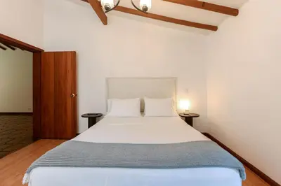a bedroom with a large white bed with two pillows at CH51 Colonial Charm Villa at El Poblado Jacuzzi in Medellín