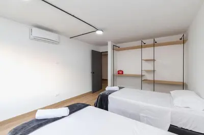 two beds in a room with white walls at B1 Apt de 3 Alcobas en Poblado Provenza con Aire in Medellín