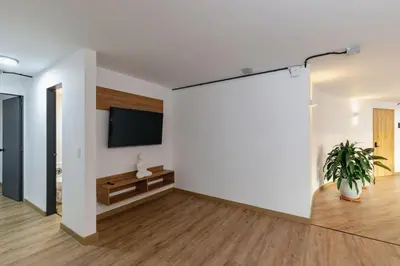 a living room with a white wall and a flat screen tv at B1 Apt de 3 Alcobas en Poblado Provenza con Aire in Medellín
