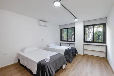 two beds in a room with two windows at B1 Apt de 3 Alcobas en Poblado Provenza con Aire in Medellín
