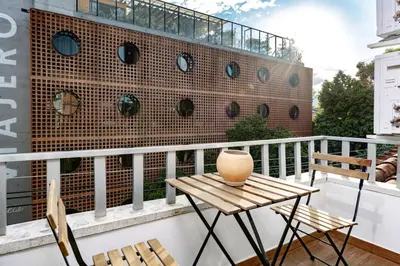 a balcony with a table and chairs and a brick wall at M54 Poblado 10BR 2 Apts with 2 Jacuzzis and AC in Medellín