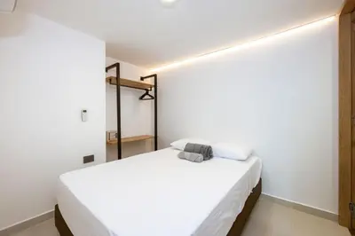 a bedroom with a white bed in a room at M54 Poblado 10BR 2 Apts with 2 Jacuzzis and AC in Medellín