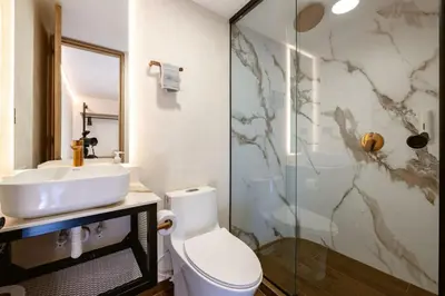 a bathroom with a toilet and a sink and a shower at M54 Poblado 10BR 2 Apts with 2 Jacuzzis and AC in Medellín