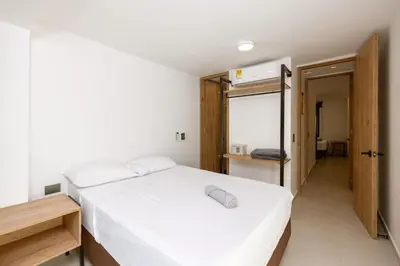 a bedroom with a white bed and a hallway at M54 Poblado 10BR 2 Apts with 2 Jacuzzis and AC in Medellín