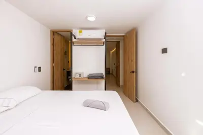 a bedroom with a white bed and a closet at M54 Poblado 10BR 2 Apts with 2 Jacuzzis and AC in Medellín