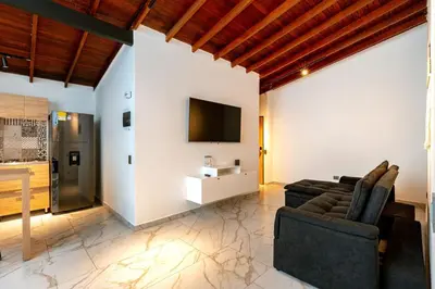 a living room with a couch and a tv on a wall at L2 2BR Laureles Apartment Jacuzzi AC in Medellín