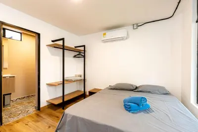 a bedroom with a bed with a blue pillow on it at L1 7BR Laureles House rooftop jacuzzi AC in Medellín