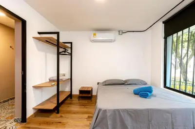 a bedroom with a bed in a room with a window at L1 7BR Laureles House rooftop jacuzzi AC in Medellín