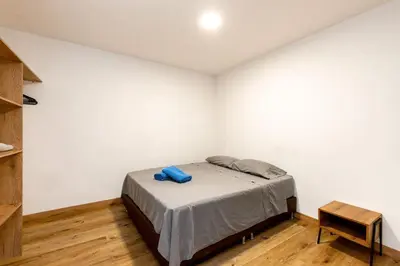 a bedroom with a bed in a white wall at L1 7BR Laureles House rooftop jacuzzi AC in Medellín