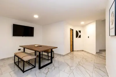 a dining room with a table and a tv on a wall at L1 7BR Laureles House rooftop jacuzzi AC in Medellín